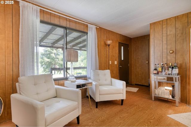 living area with wooden walls and light wood finished floors