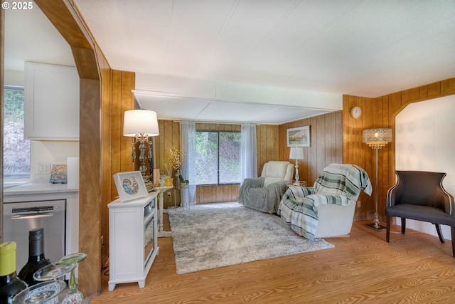 living area featuring light wood-style flooring and wood walls