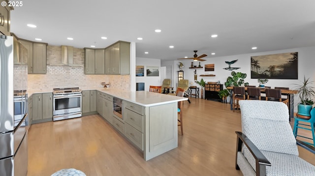 1307 Moore St Unit 704, Brookings, OR 97415 - kitchen featuring stainless steel appliances, gray cabinets, wall chimney exhaust hood, a peninsula, and a ceiling fan