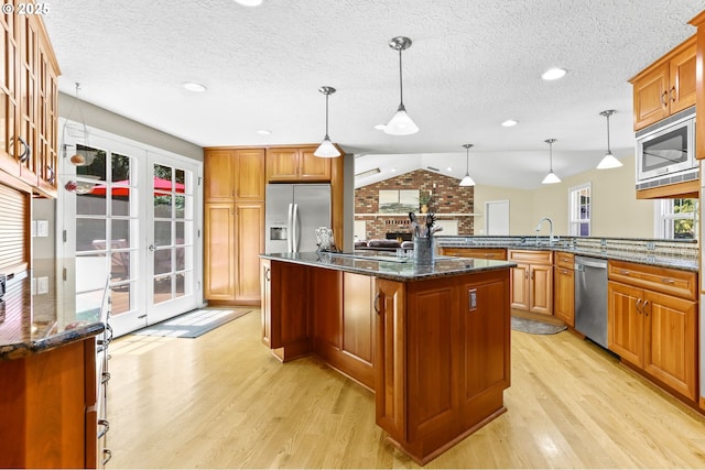 37330 SE Dodge Park Blvd, Boring, OR 97009 - kitchen featuring appliances with stainless steel finishes, light wood finished floors, a sink, lofted ceiling, and a kitchen island