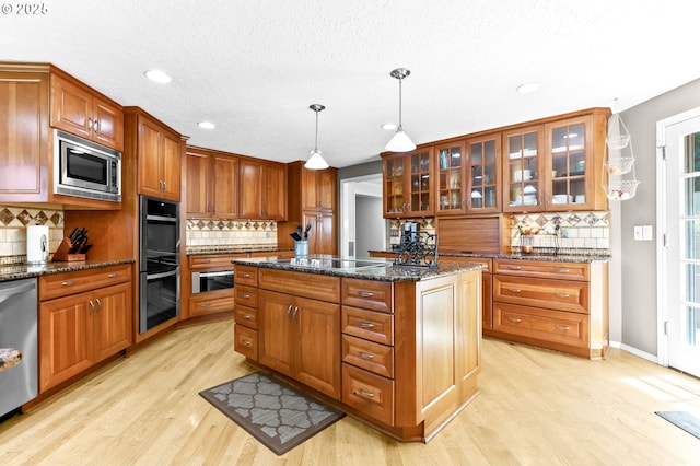 37330 SE Dodge Park Blvd, Boring, OR 97009 - kitchen featuring stainless steel appliances, backsplash, light wood-type flooring, a kitchen island, and recessed lighting