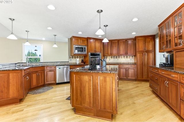 37330 SE Dodge Park Blvd, Boring, OR 97009 - kitchen featuring appliances with stainless steel finishes, light wood finished floors, a center island, dark stone countertops, and recessed lighting