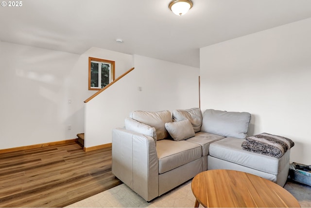living room with light wood-style floors, baseboards, and stairs