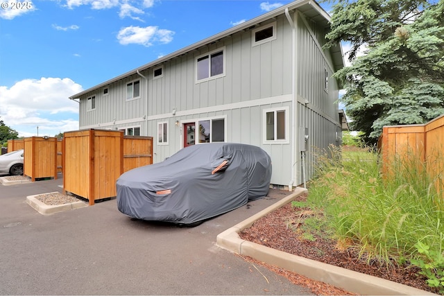 rear view of property with fence and board and batten siding