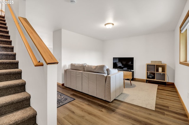 living room with wood finished floors, stairs, and baseboards