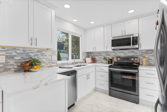 288 NE Hyde Cir, Hillsboro, OR 97124 - kitchen with stainless steel appliances, light marble finish flooring, white cabinetry, recessed lighting, and a sink