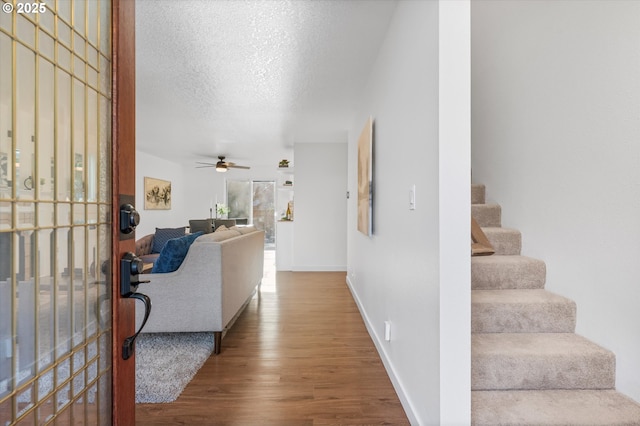 288 NE Hyde Cir, Hillsboro, OR 97124 - entrance foyer featuring wood finished floors, stairs, a ceiling fan, a textured ceiling, and baseboards