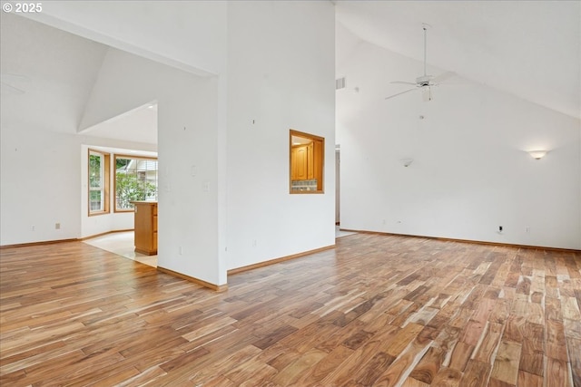 unfurnished living room featuring high vaulted ceiling, light wood-style flooring, a ceiling fan, and baseboards