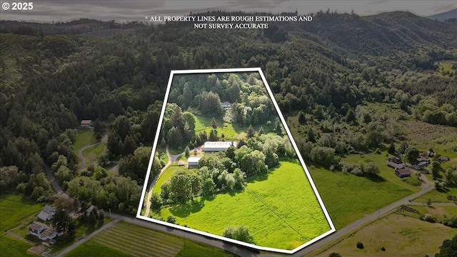 view of property location with a forest, property parcel outlined, and mountains