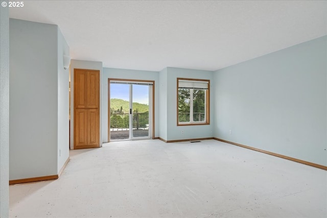empty room featuring baseboards and concrete flooring