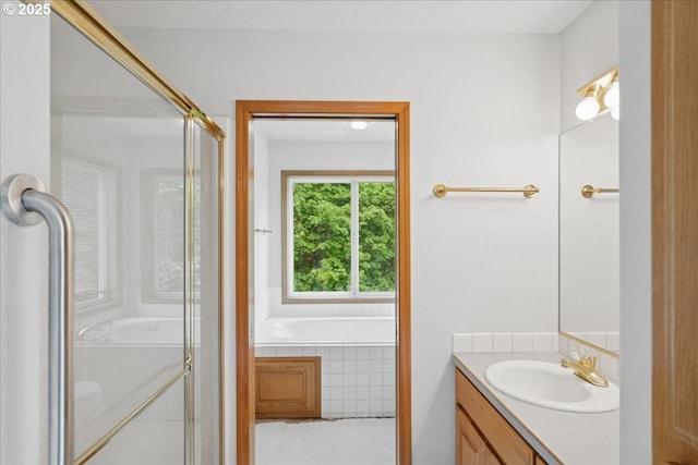 bathroom featuring vanity, a garden tub, and a stall shower