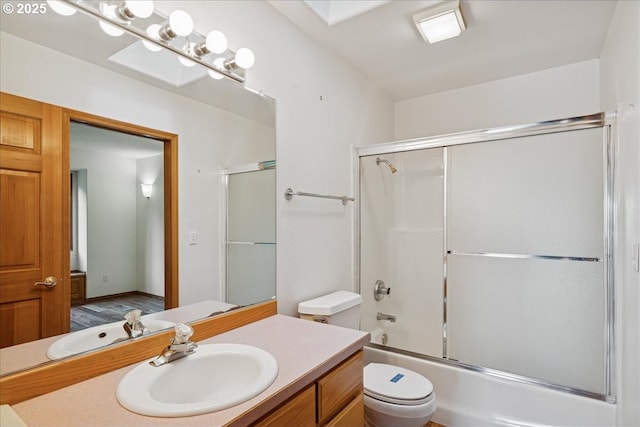 bathroom featuring toilet, vanity, and enclosed tub / shower combo