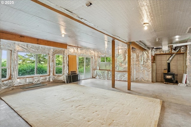 unfurnished sunroom featuring a wood stove