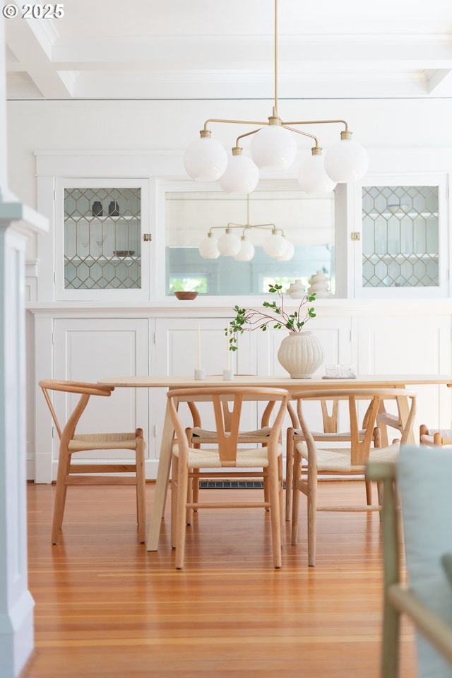 dining area with light wood finished floors and ornamental molding