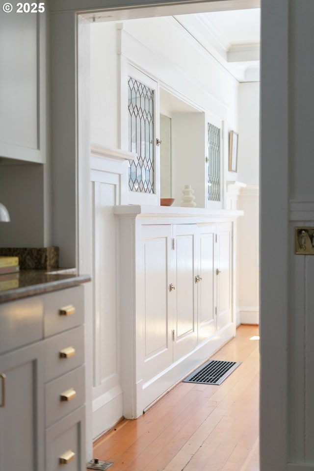 detailed view of a decorative wall, wood finished floors, and ornamental molding
