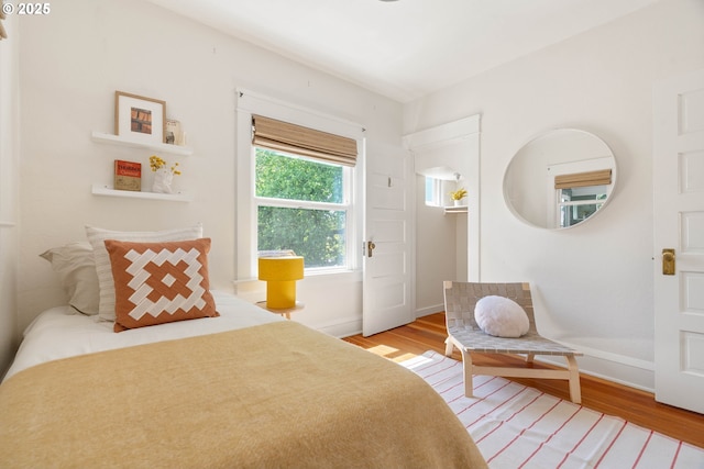 bedroom with light wood-style flooring and baseboards