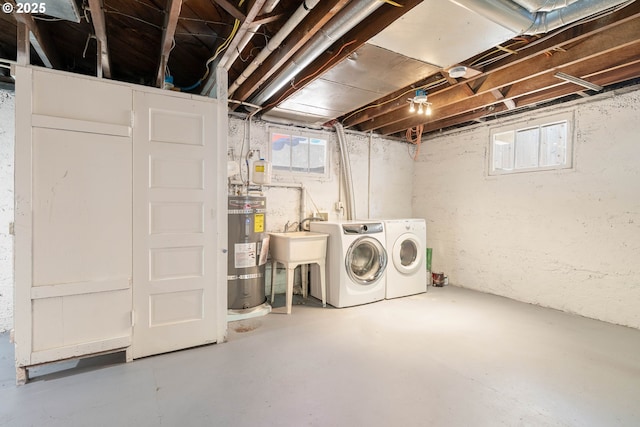 below grade area featuring secured water heater, separate washer and dryer, healthy amount of natural light, and a sink