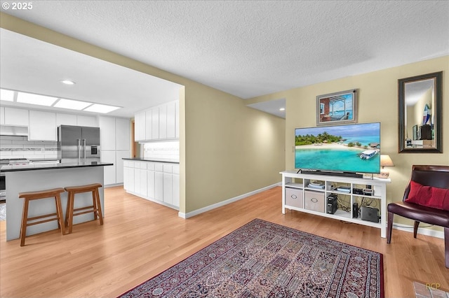 15645 NE Russell Pl, Portland, OR 97230 - living room featuring light wood-type flooring and a textured ceiling