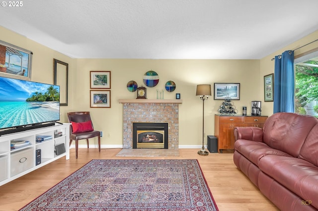 15645 NE Russell Pl, Portland, OR 97230 - living room with wood finished floors, a fireplace, and a textured ceiling