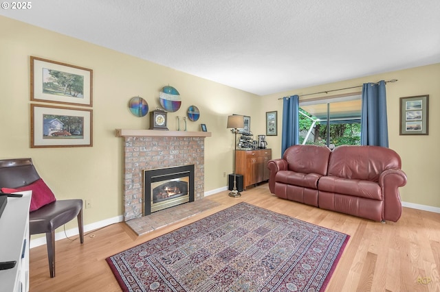 15645 NE Russell Pl, Portland, OR 97230 - living room with wood finished floors, a fireplace, and a textured ceiling
