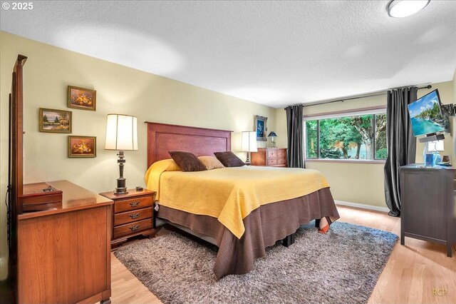 15645 NE Russell Pl, Portland, OR 97230 - bedroom featuring light wood-type flooring and a textured ceiling