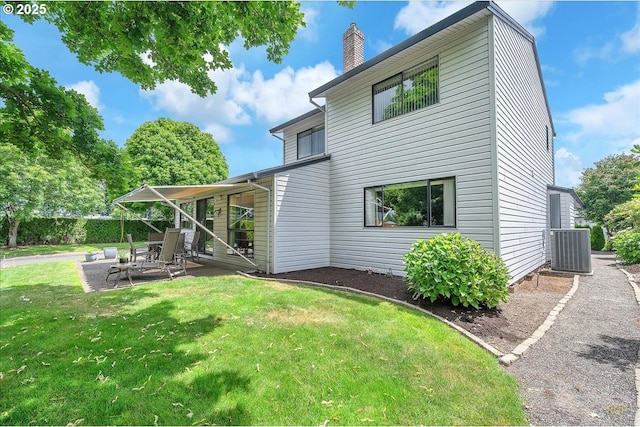 15645 NE Russell Pl, Portland, OR 97230 - back of house featuring a patio area, a lawn, and a chimney