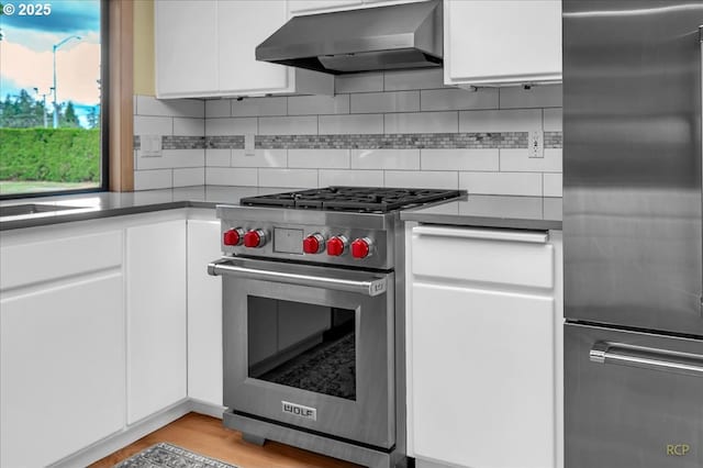 15645 NE Russell Pl, Portland, OR 97230 - kitchen featuring appliances with stainless steel finishes, extractor fan, white cabinetry, and backsplash