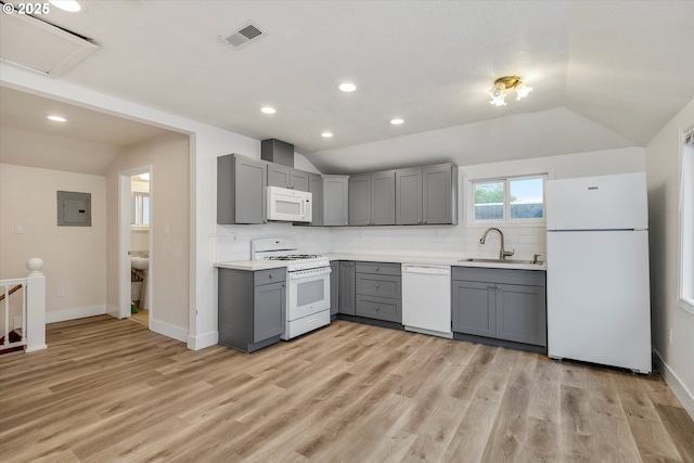 kitchen with white appliances, lofted ceiling, gray cabinets, and sink