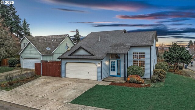 view of front of home with a garage and a lawn