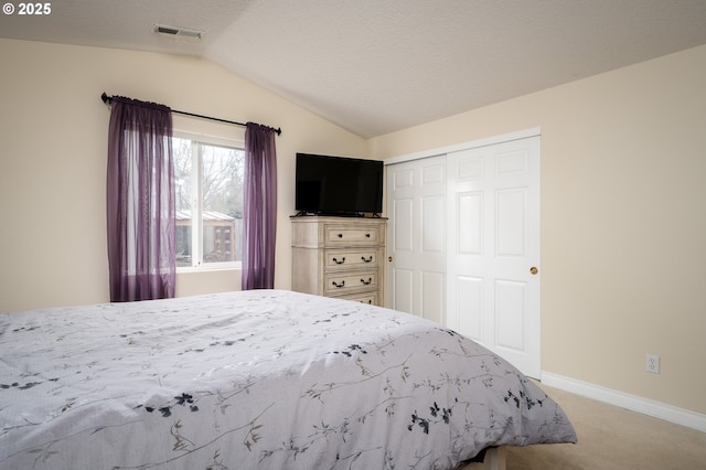 unfurnished bedroom featuring baseboards, visible vents, carpet floors, lofted ceiling, and a closet