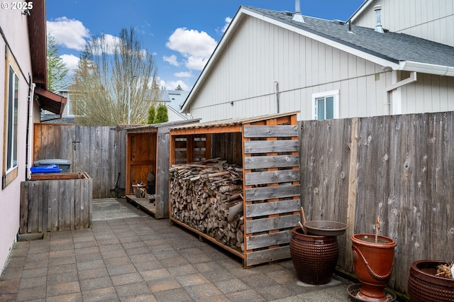 view of patio with an outbuilding and fence