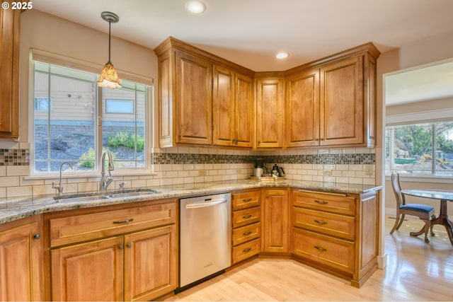 1329 NW Horn Ave, Pendleton, OR 97801 - kitchen featuring stainless steel dishwasher, a sink, brown cabinets, light stone countertops, and backsplash