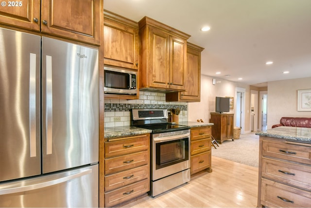 1329 NW Horn Ave, Pendleton, OR 97801 - kitchen with stainless steel appliances, open floor plan, backsplash, brown cabinets, and recessed lighting