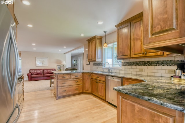 1329 NW Horn Ave, Pendleton, OR 97801 - kitchen with stainless steel appliances, a sink, a peninsula, light wood-type flooring, and backsplash