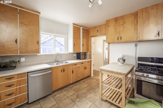 kitchen with tasteful backsplash, appliances with stainless steel finishes, light tile patterned flooring, and sink