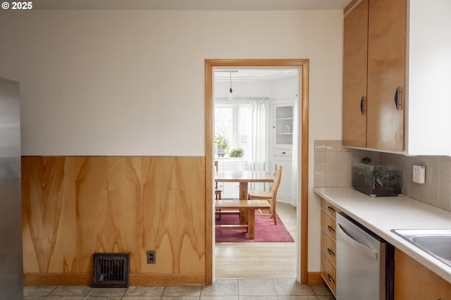 kitchen with sink, stainless steel dishwasher, backsplash, and light tile patterned floors