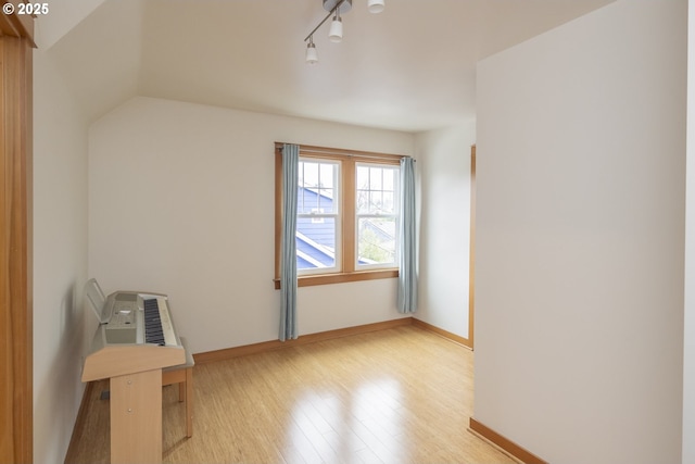 unfurnished room with track lighting and light hardwood / wood-style floors