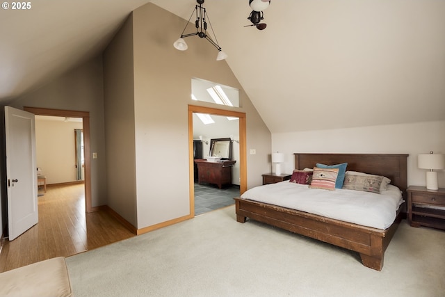 bedroom featuring lofted ceiling, hardwood / wood-style flooring, and ensuite bathroom