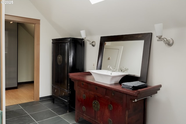 bathroom with vanity, vaulted ceiling, and tile patterned floors