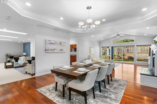 dining room with recessed lighting, crown molding, lofted ceiling, ceiling fan with notable chandelier, and wood finished floors