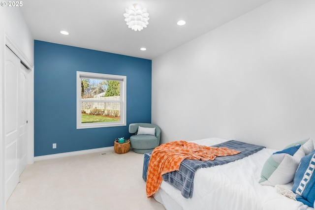 carpeted bedroom featuring a closet, recessed lighting, and baseboards