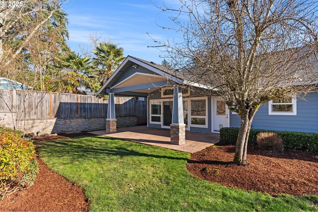 rear view of house featuring a yard, a patio, and fence