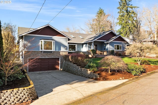 view of front of house with stone siding, a garage, and driveway