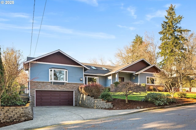 view of front of home featuring an attached garage, driveway, and stone siding
