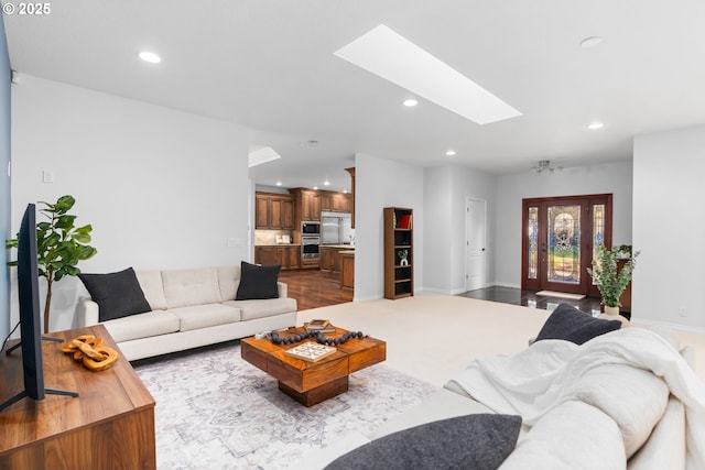 living room with recessed lighting, baseboards, and a skylight