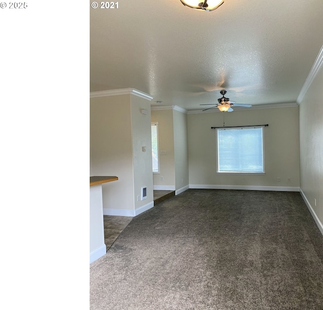 unfurnished room featuring dark carpet, a ceiling fan, a textured ceiling, ornamental molding, and baseboards