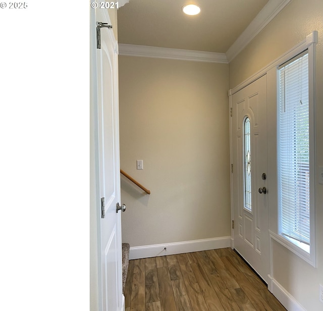 foyer featuring ornamental molding, wood finished floors, and baseboards