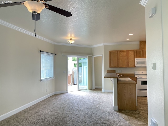 kitchen featuring white appliances, a ceiling fan, open floor plan, ornamental molding, and light carpet