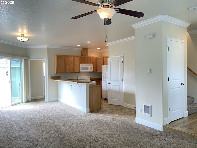 kitchen with white appliances, a peninsula, ornamental molding, baseboards, and brown cabinetry