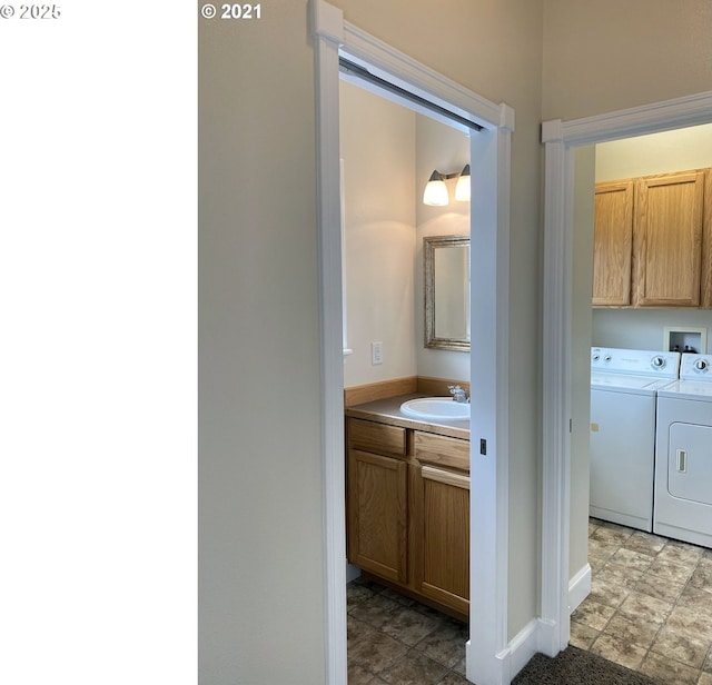 laundry room featuring washer and clothes dryer, cabinet space, and baseboards